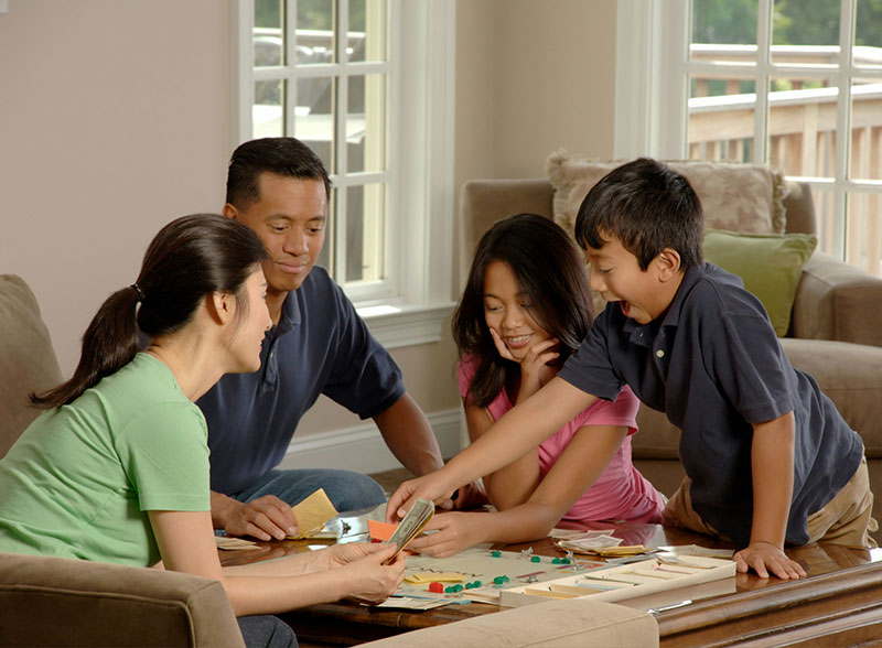 Family playing board game smiling happy boy