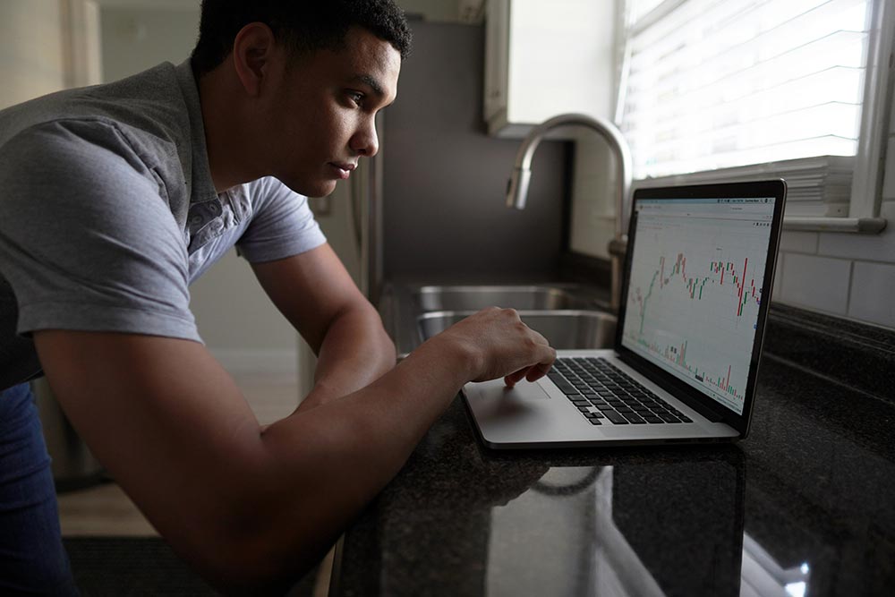 Finance-and-Investing---man-in-gray-t-shirt-using-macbook-pro-looking-at-stock-charts.