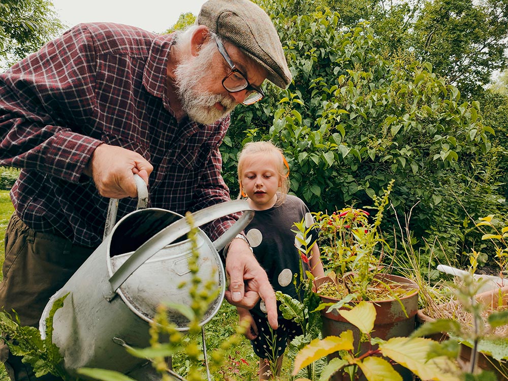 gardening-a-man-and-a-child-looking-at-a-plant-in-the-garden
