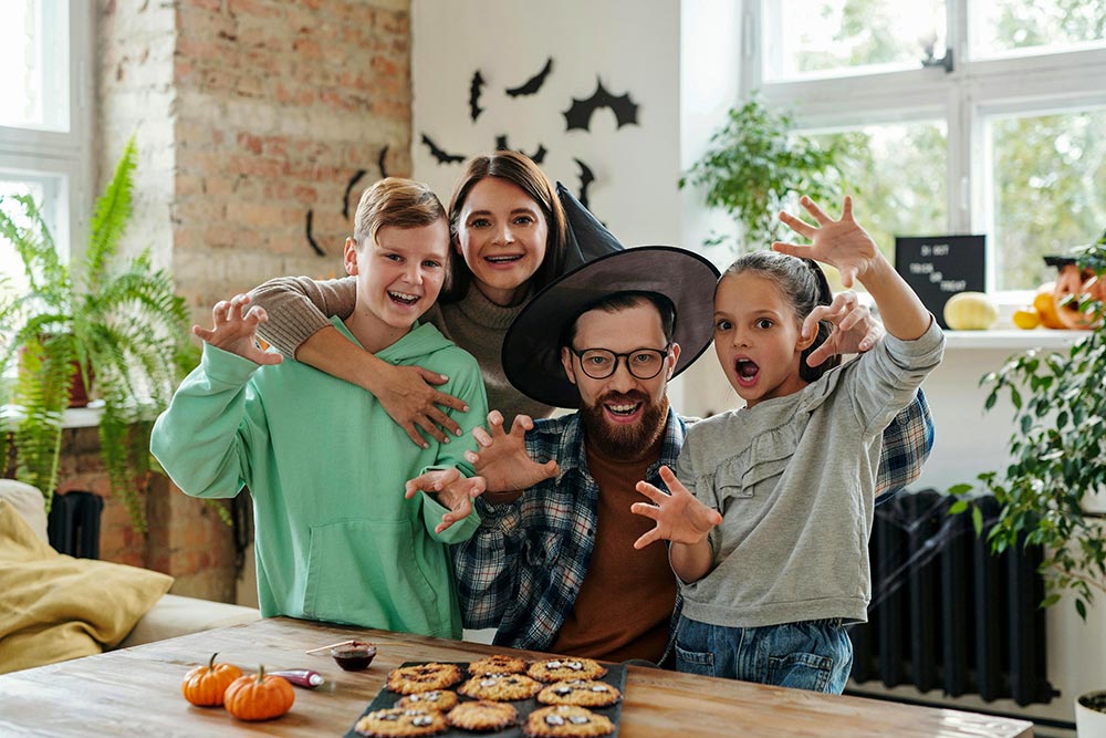 happy-family-at-kitchen-table-decorating-halloween-cookies