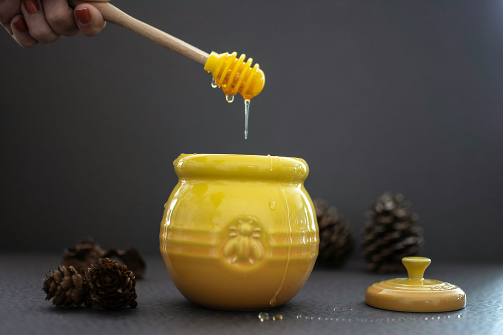 opened-yellow-ceramic-jar-beside-pine-cones