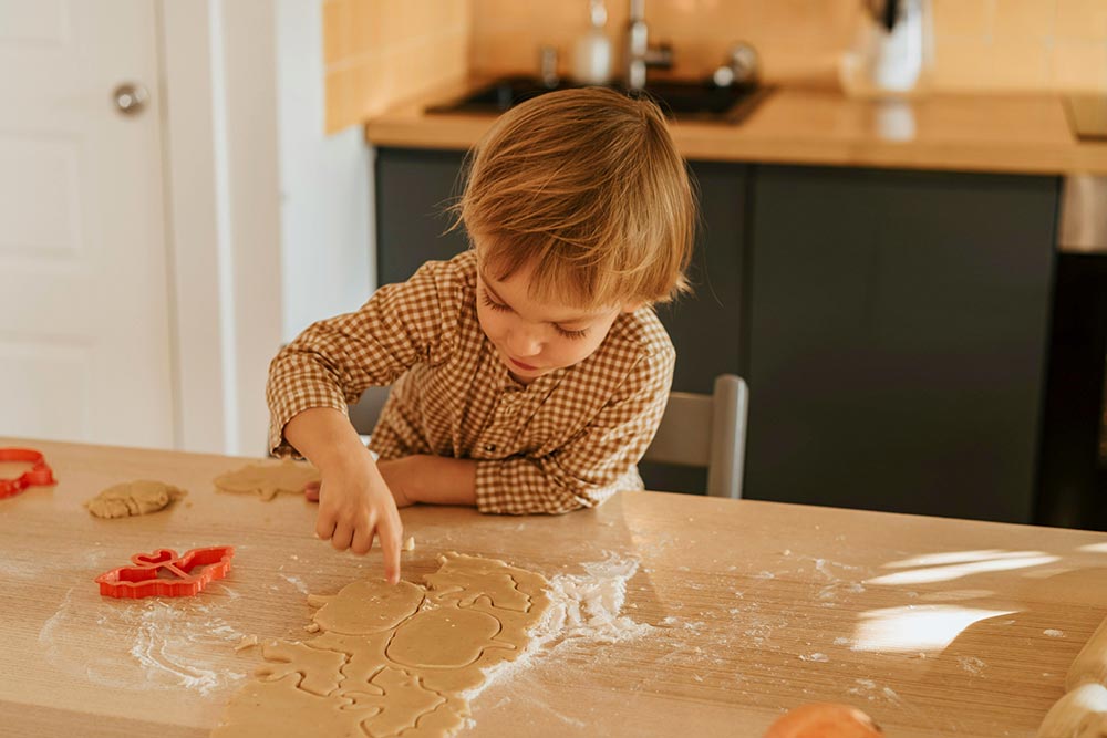 young-boy-separating-shaped-halloween-shaped-cookie-dough-pieces